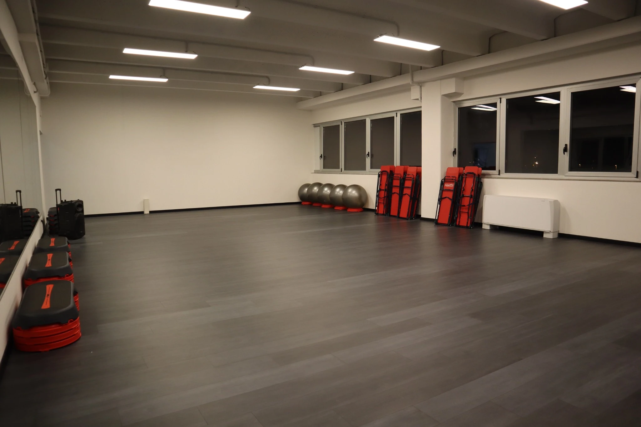 Sala a corpo libero con specchi, step e piccoli attrezzi